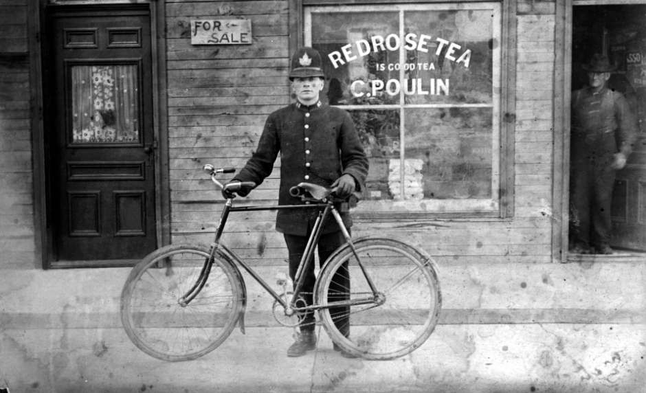 Police officer James Fagan is posing outside C Poulin's store at 324 Rochester St - City of Ottawa Archives CA001216.jpg